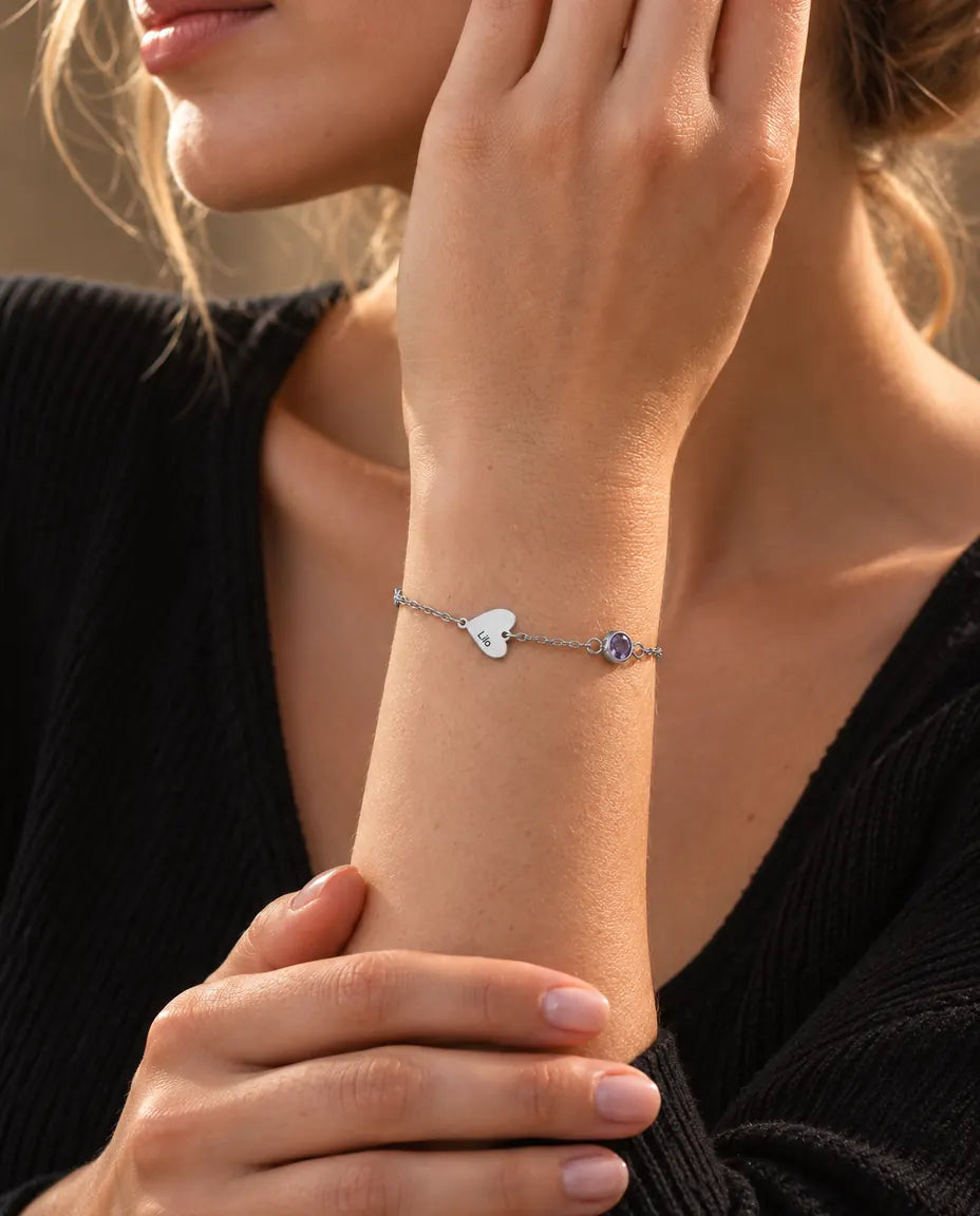 Donna che indossa il bracciale con nomi e pietre di nascita con un solo cuore inciso