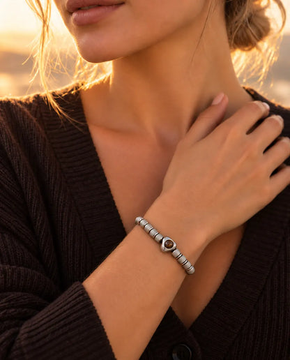 Donna con la mano sulla clavicola che indossa il bracciale argentato con perla a cuore e foto dentro
