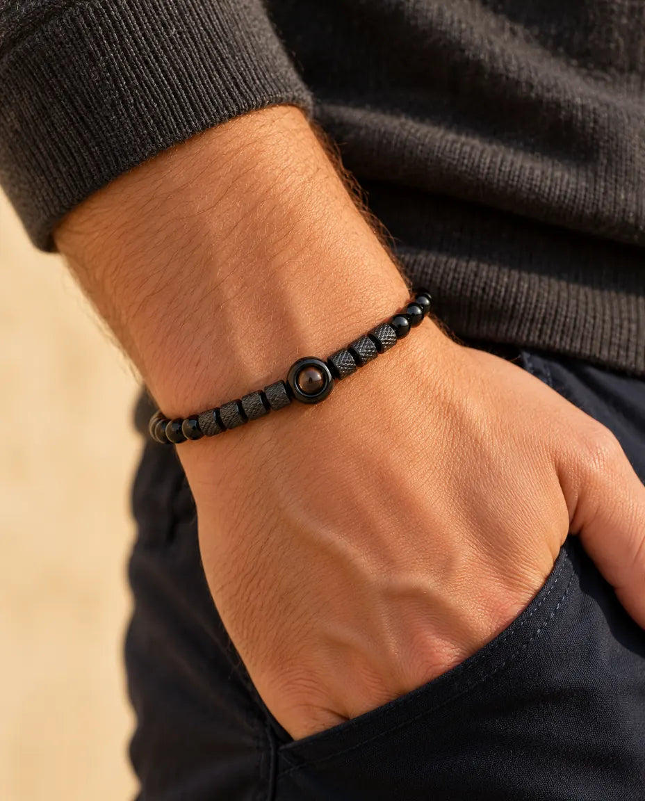 Uomo che indossa il bracciale di perline nero con foto dentro, con la mano infilata in tasca