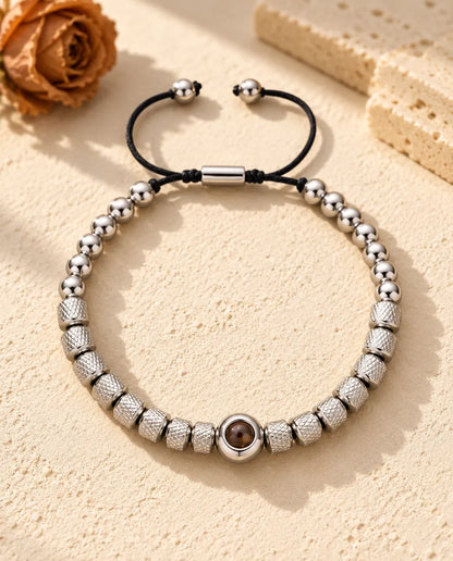Bracciale di perline zigrinate argentato con una perla tonda che custodisce la foto