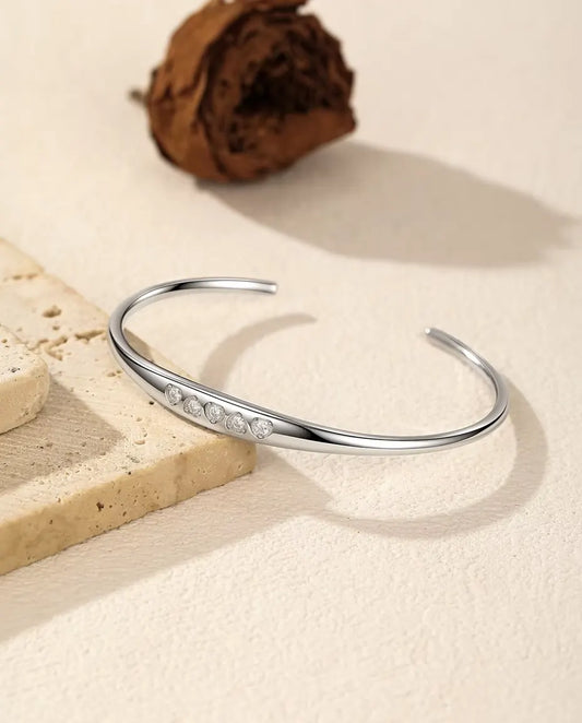 Bracciale Rigido Moissanite in Argento 925 - adagiato su una lastra di travertino