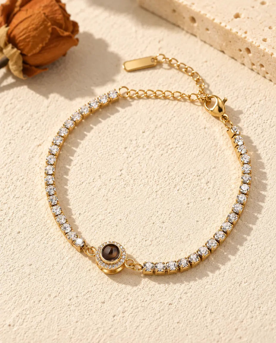 Vista dall'alto del bracciale tennis dorato con charm halo e la sua catenella di prolunga