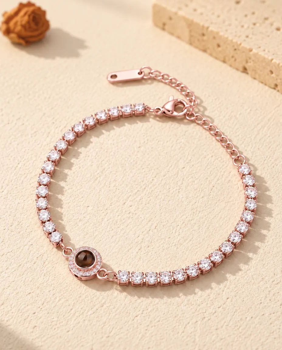 Bracciale tennis color oro rosa con charm halo, chiusura a moschettone e catenella di prolunga
