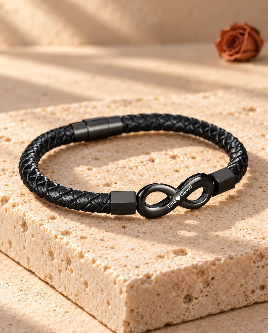 Vista di tre quarti del bracciale uomo con infinito inciso e chiusura magnetica a cilindro sul travertino