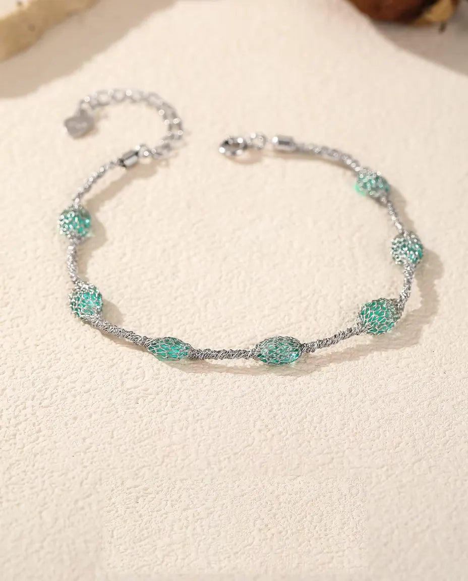 Bracciale Zirconi in Gabbia in Argento 925 - disteso su una superficie chiara ruvida, con chiusura e prolunga