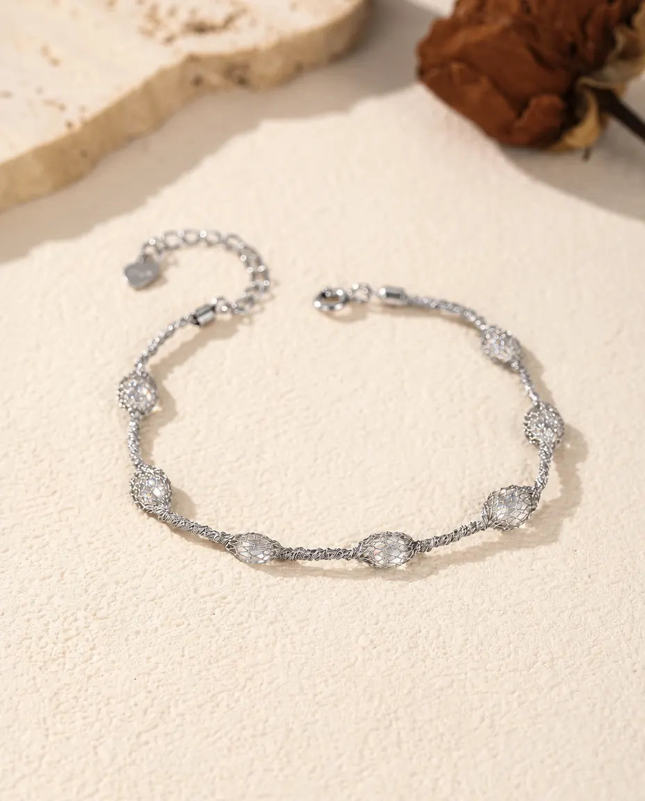 Bracciale Zirconi in Gabbia in Argento 925 - versione con zirconi bianchi, disteso su una superficie chiara