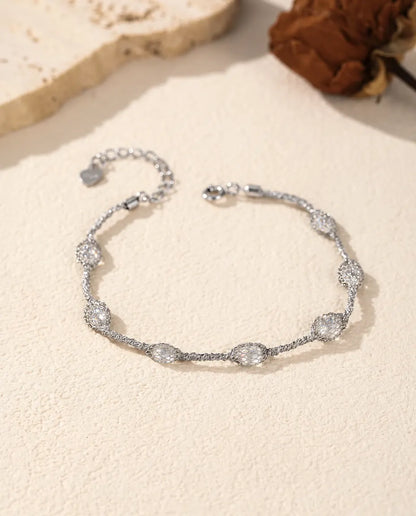 Bracciale Zirconi in Gabbia in Argento 925 - versione con zirconi bianchi, disteso su una superficie chiara