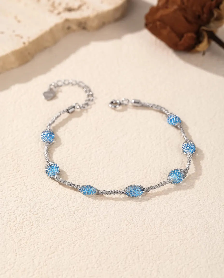 Bracciale Zirconi in Gabbia in Argento 925 - versione con zirconi blu, disteso su una superficie chiara
