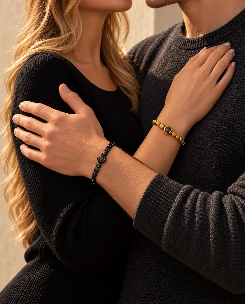 Coppia abbracciata: lei porta il bracciale di perline dorato con foto dentro, lui quello nero