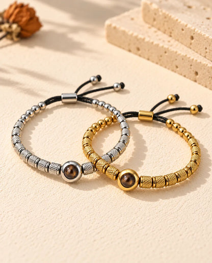 Bracciali di perline argentato e dorato con foto dentro intrecciati come due anelli sul gesso