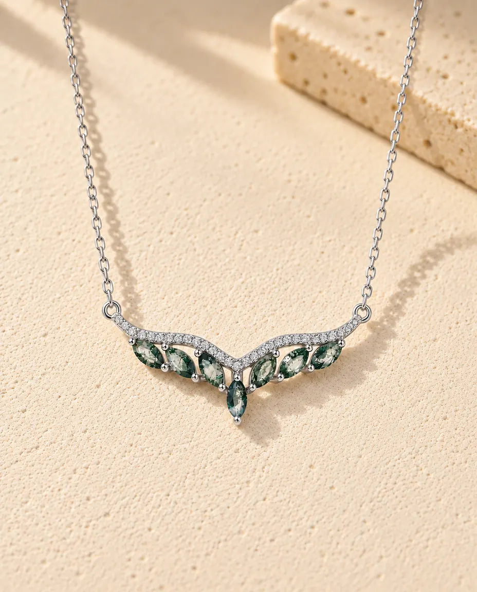 Collana Agata Muschiata in Argento 925 - appoggiata su una superficie chiara ruvida accanto a un blocco di travertino