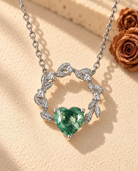 Collana Cuore Agata Muschiata in Argento 925 - appoggiata su una superficie chiara ruvida accanto a un blocco di travertino