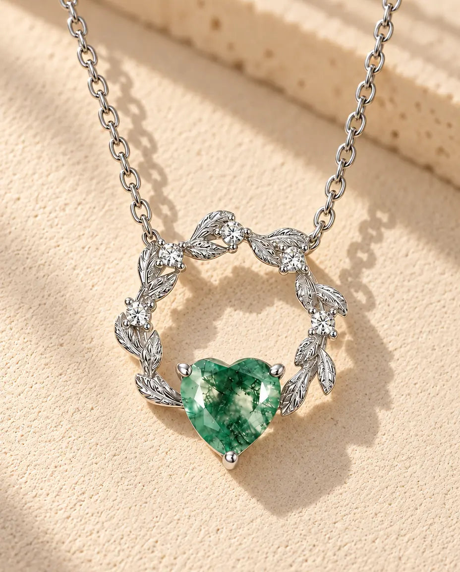 Collana Cuore Agata Muschiata in Argento 925 - appoggiata su una superficie chiara ruvida accanto a un blocco di travertino