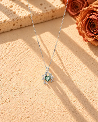Collana Agata Muschiata Cuore con Rami in Argento 925 - la collana intera distesa a lunga V su una superficie chiara ruvida