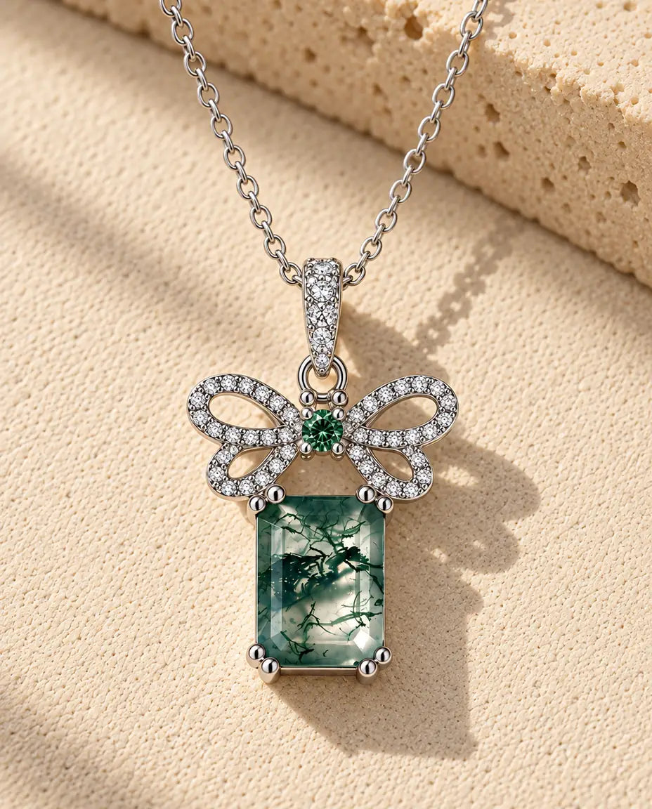 Collana Agata Muschiata Fiocco in Argento 925 - appoggiata su una superficie chiara ruvida accanto a un blocco di travertino