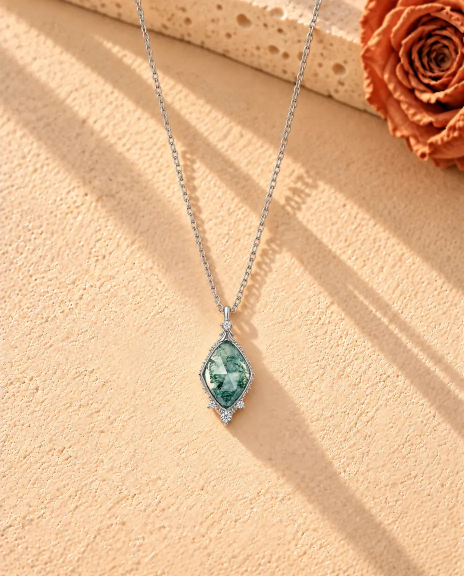 Collana Agata Muschiata a Losanga in Argento 925 - la collana intera distesa a lunga V su una superficie chiara ruvida