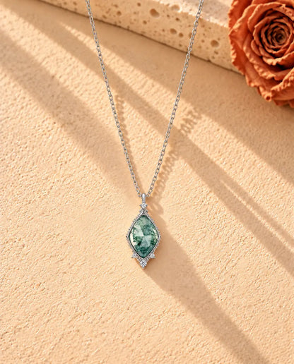 Collana Agata Muschiata a Losanga in Argento 925 - la collana intera distesa a lunga V su una superficie chiara ruvida