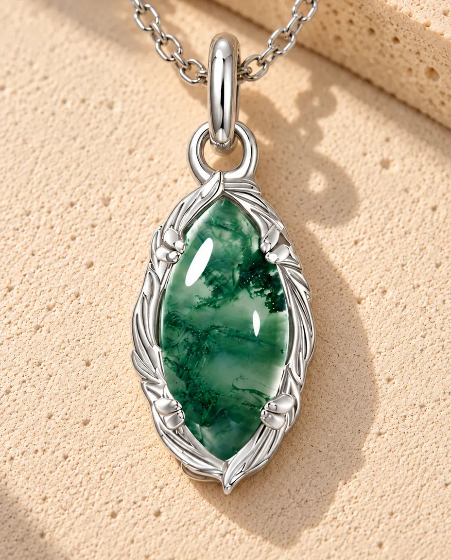 Collana Agata Muschiata Marquise in Argento 925 - appoggiata su una superficie chiara ruvida accanto a un blocco di travertino