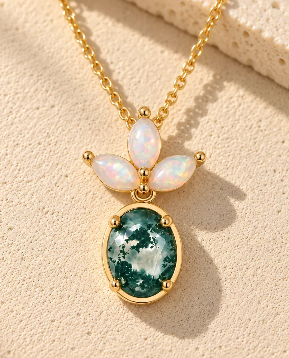 Collana Agata Muschiata e Opale in Argento 925 Placcato Oro - appoggiata su una superficie chiara ruvida accanto a un blocco di travertino