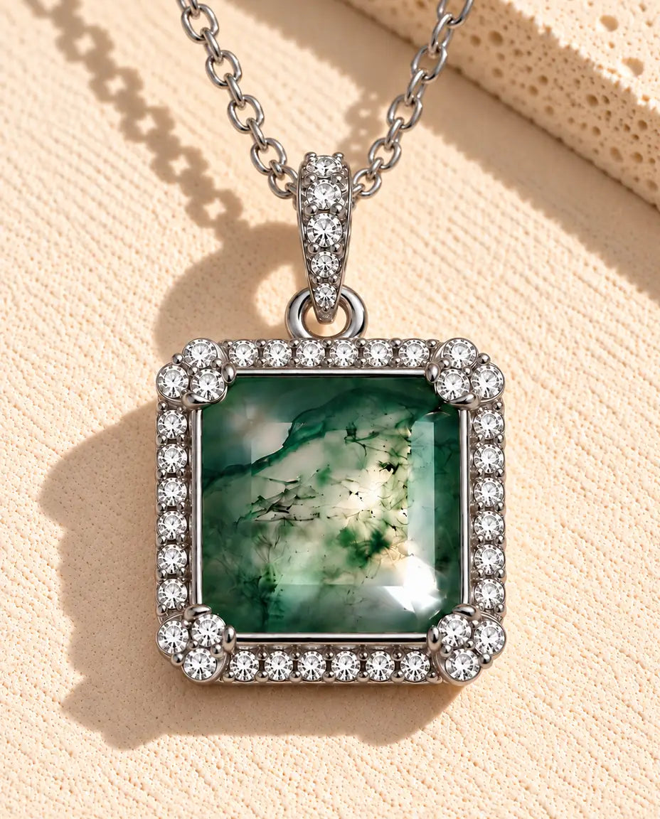 Collana Agata Muschiata Quadrata in Argento 925 - appoggiata su una superficie chiara ruvida accanto a un blocco di travertino