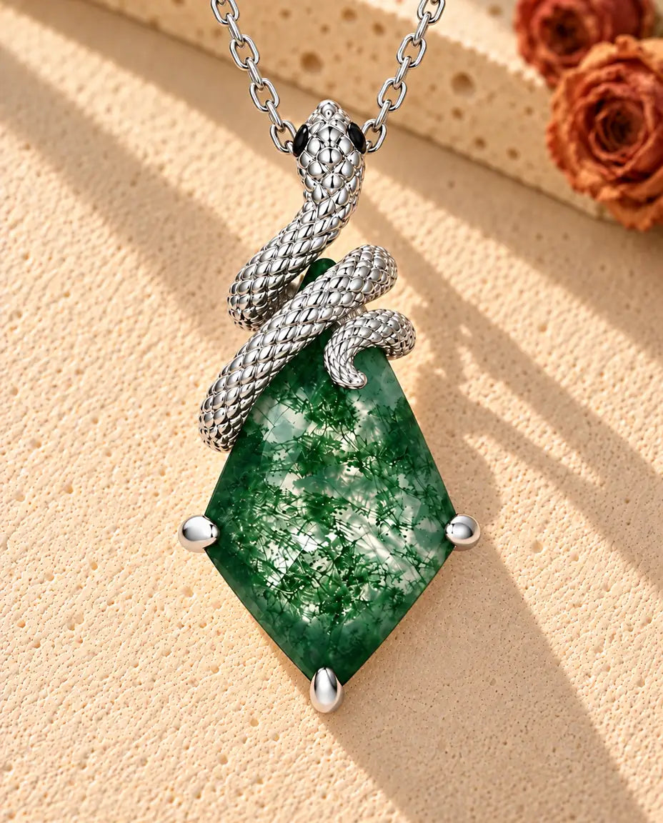 Collana Agata Muschiata Serpente in Argento 925 - appoggiata su una superficie chiara ruvida accanto a un blocco di travertino
