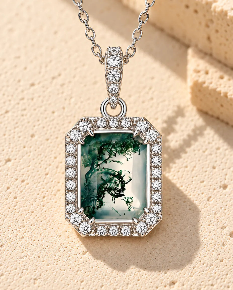 Collana Agata Muschiata Taglio Smeraldo in Argento 925 - appoggiata su una superficie chiara ruvida accanto a un blocco di travertino