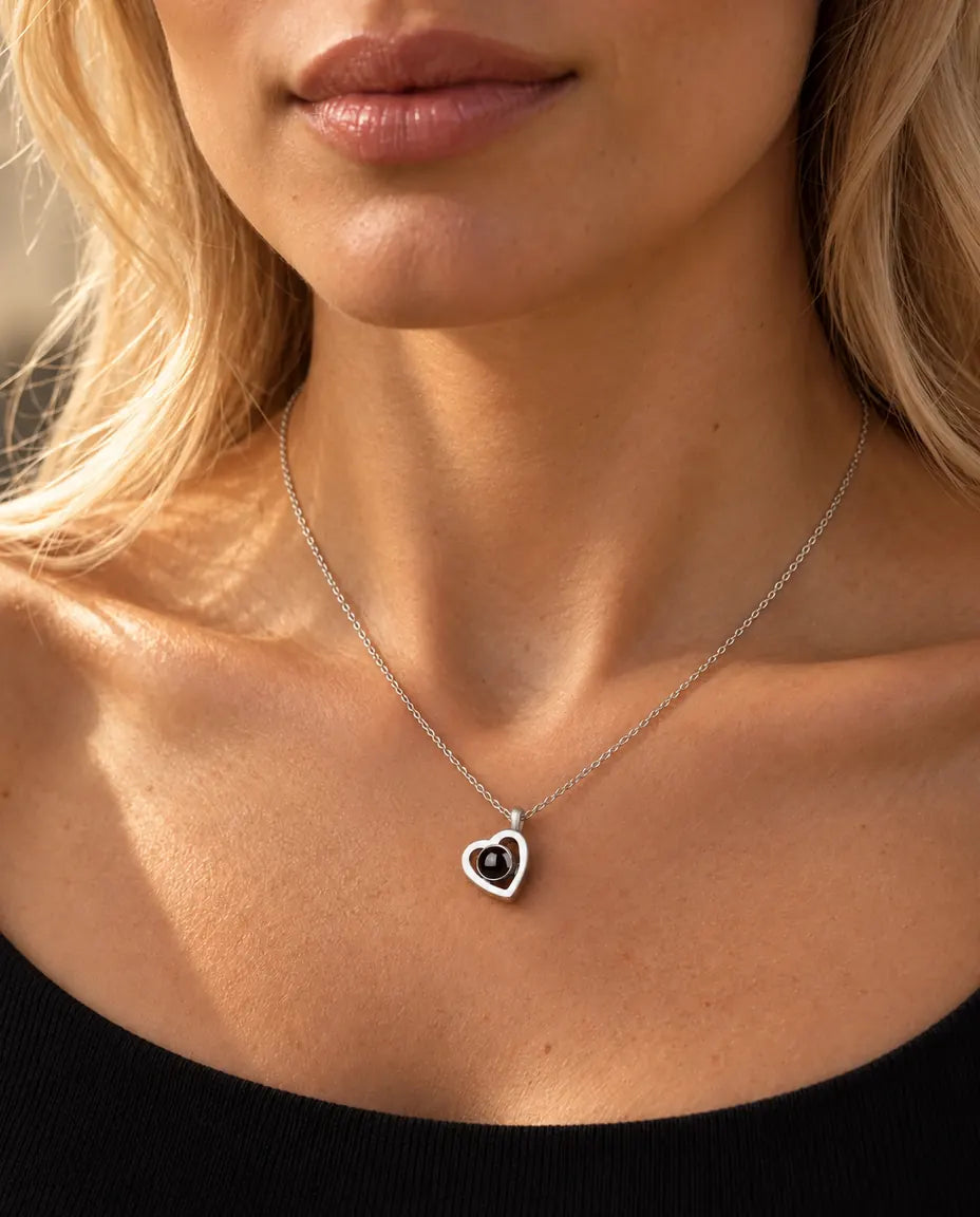Donna con un top nero in maglia che indossa la piccola collana doppio cuore in argento 925