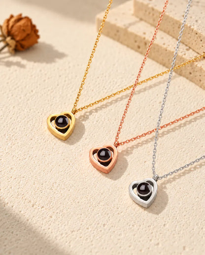 Collane doppio cuore con foto dentro: dorata, color oro rosa e in argento, in diagonale sul gesso