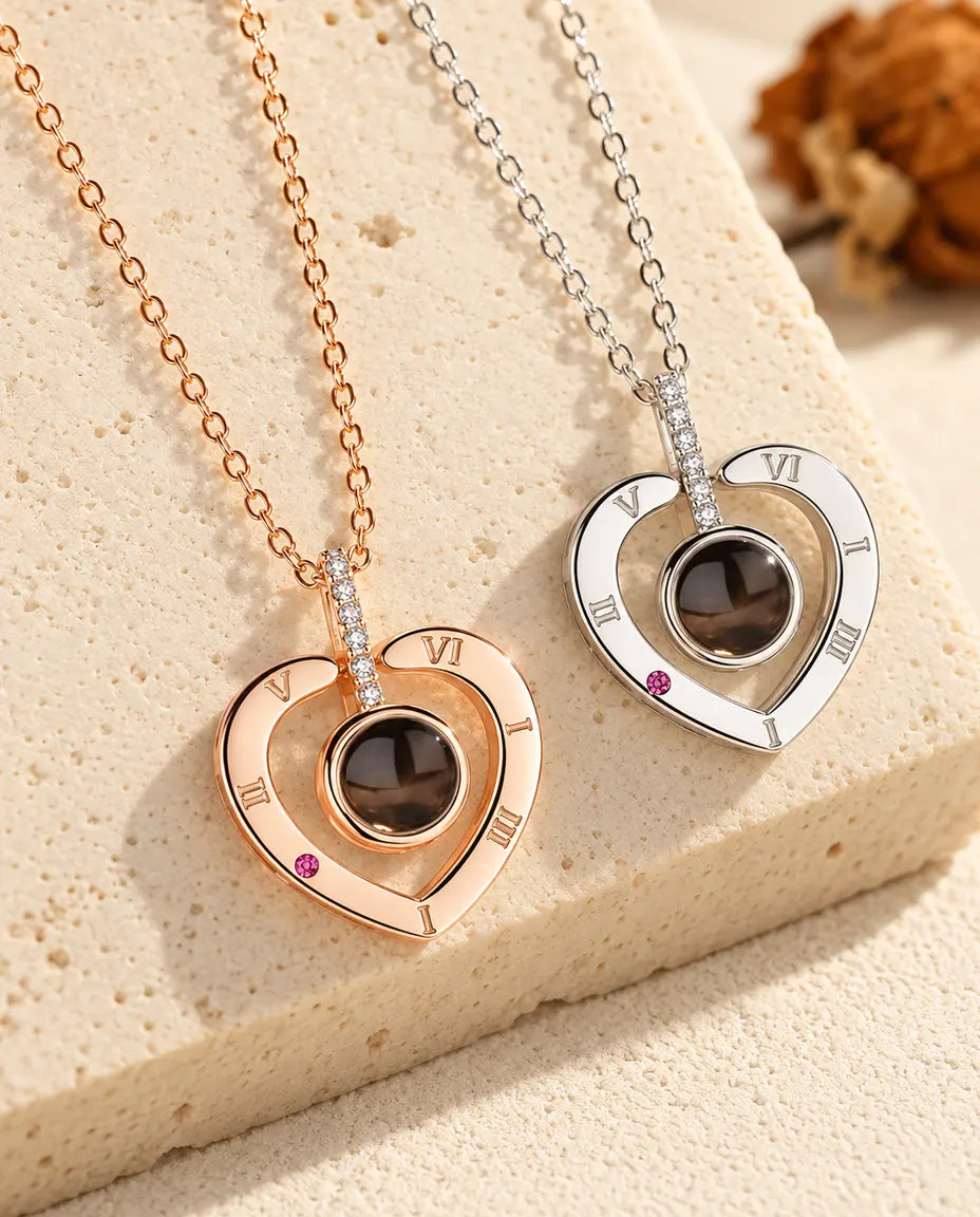 Collane a cuore con numeri romani, color oro rosa e in argento, una accanto all'altra
