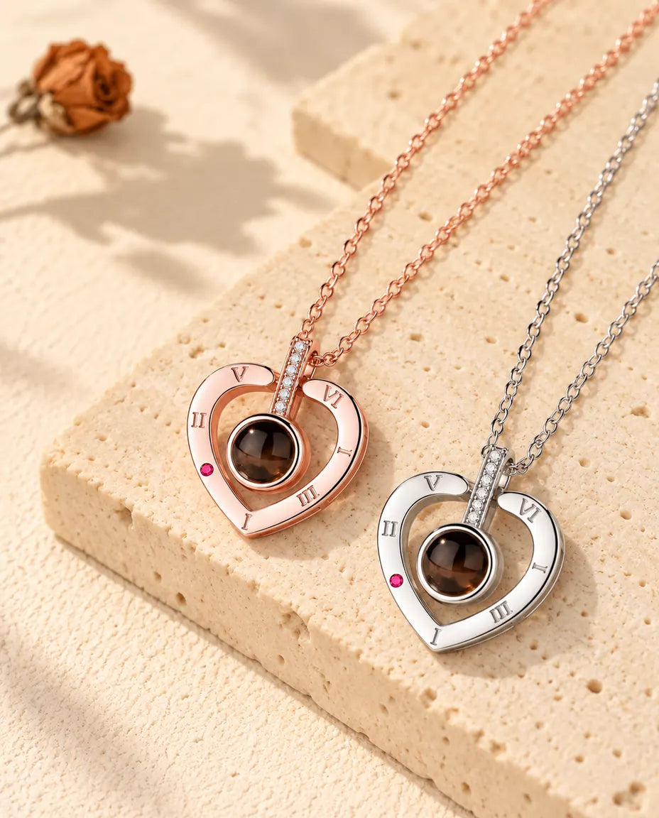 Collane a cuore con numeri romani color oro rosa e in argento disposte in diagonale sul gesso