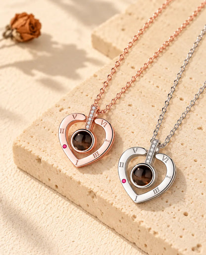 Collane a cuore con numeri romani color oro rosa e in argento disposte in diagonale sul gesso
