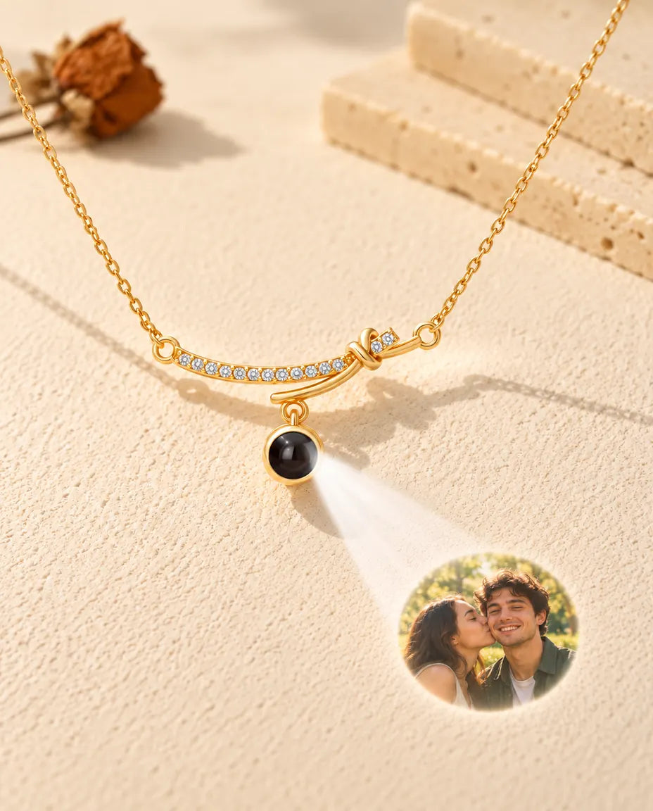 Collana dorata a barra curva che proietta la foto di una coppia su una parete di intonaco crema