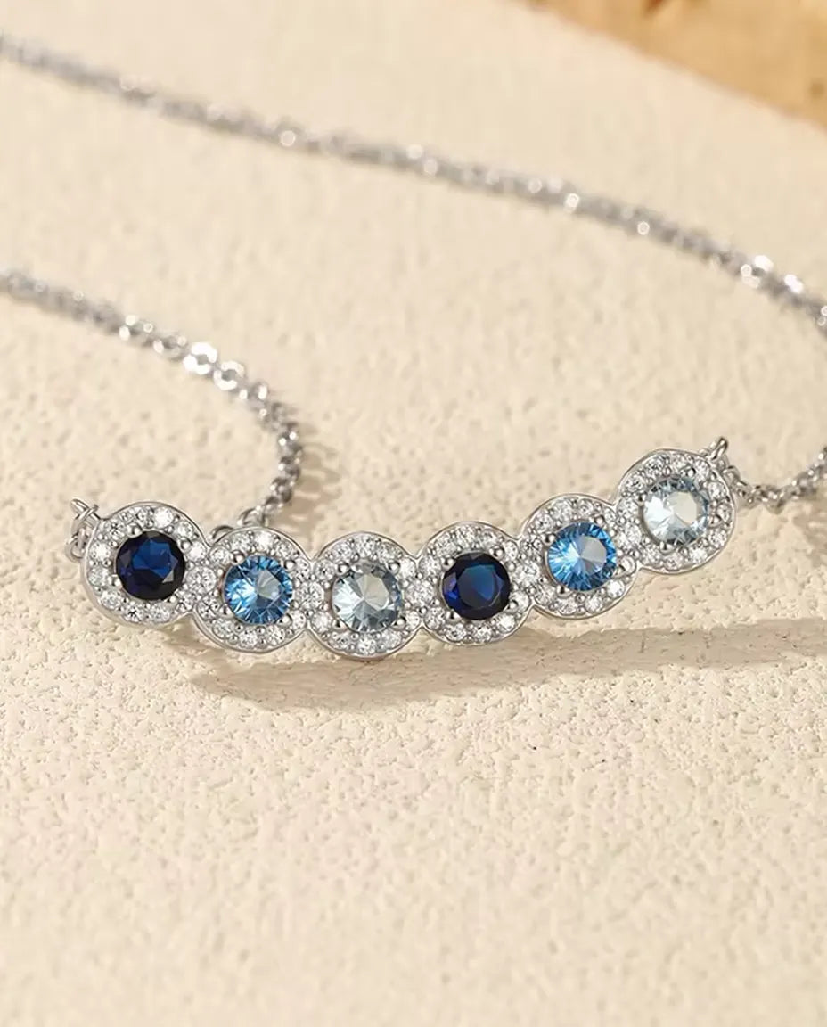 Collana Barra Sfumata Blu - sei pietre blu con halo di pavé, barra curva 34 mm, argento 925, catena 40+5 cm