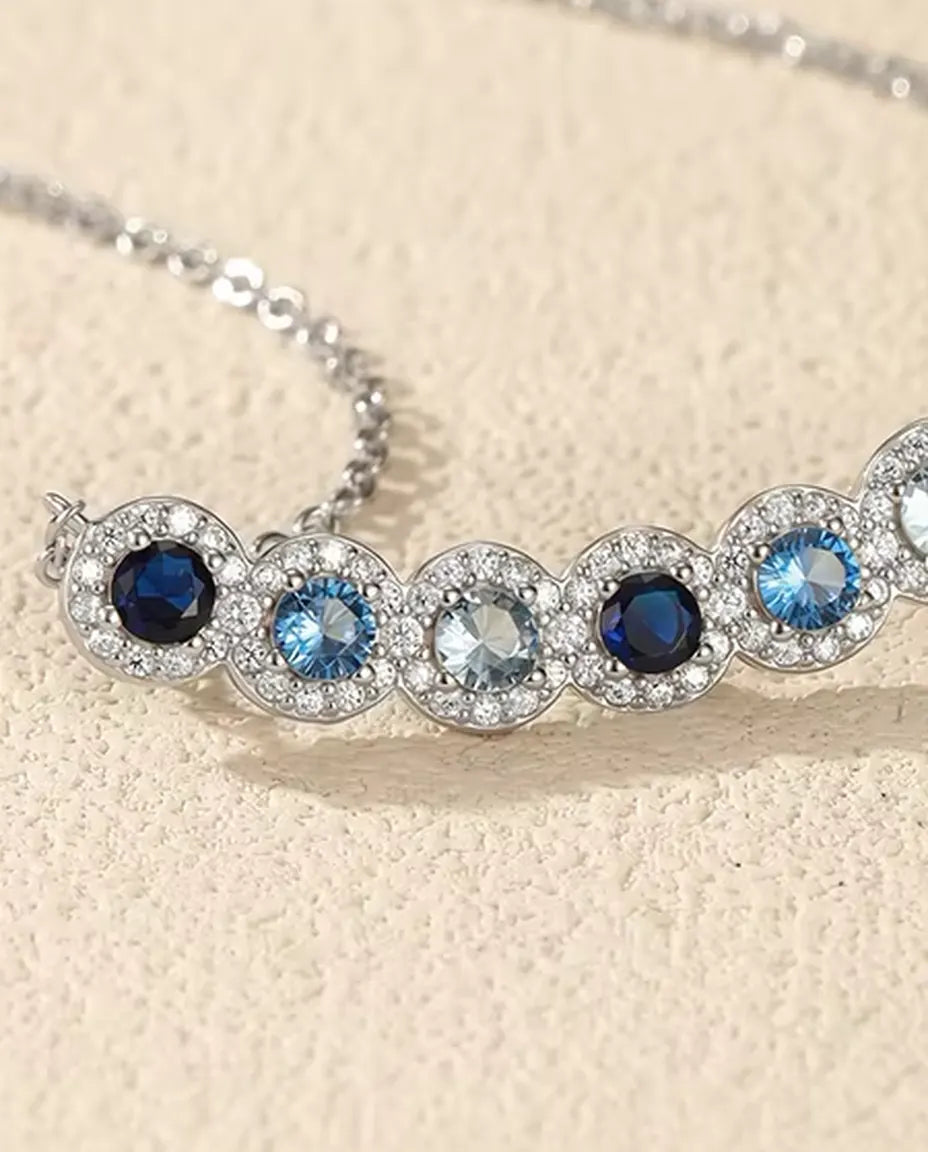 Collana Barra Sfumata Blu - sei pietre blu con halo di pavé, barra curva 34 mm, argento 925, catena 40+5 cm