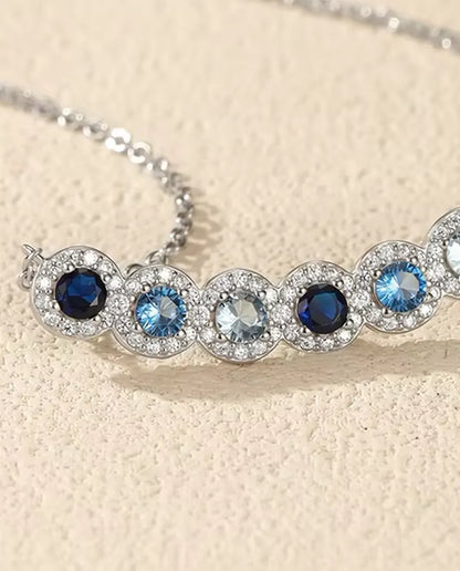 Collana Barra Sfumata Blu - sei pietre blu con halo di pavé, barra curva 34 mm, argento 925, catena 40+5 cm