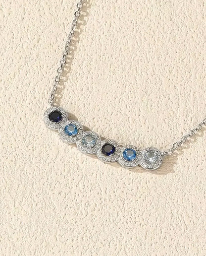 Collana Barra Sfumata Blu - sei pietre blu con halo di pavé, barra curva 34 mm, argento 925, catena 40+5 cm