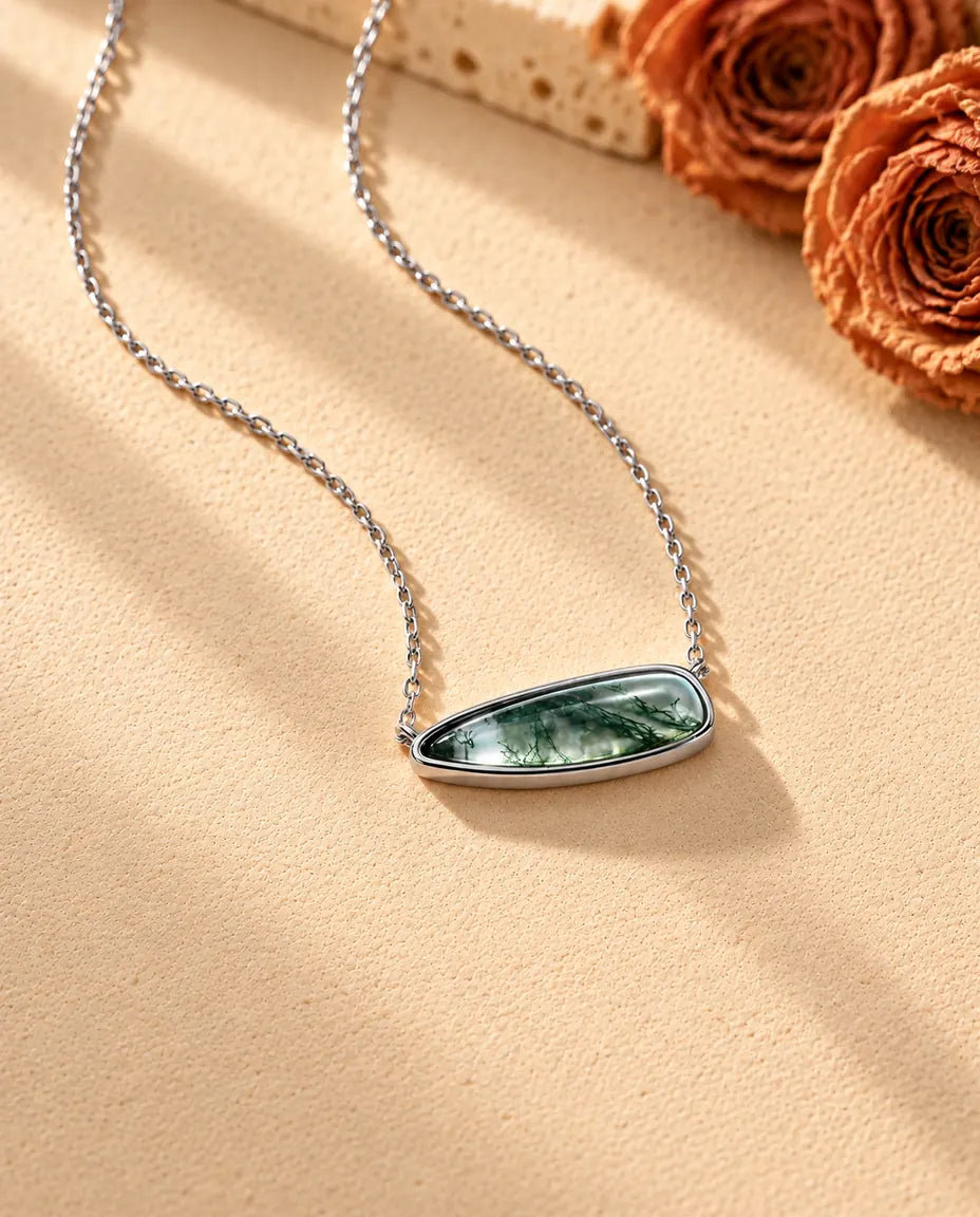 Collana Barretta Agata Muschiata in Argento 925 - vista di tre quarti su una superficie chiara ruvida