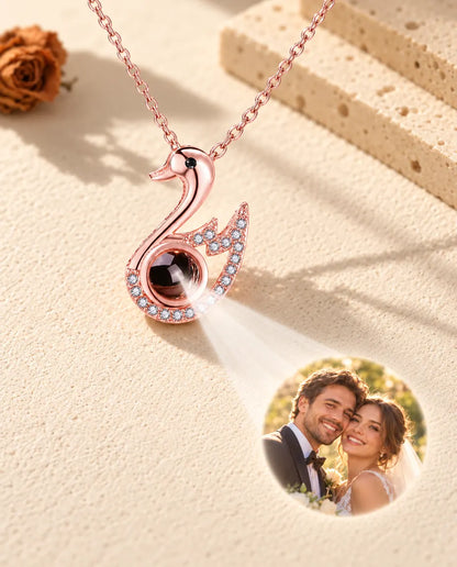Collana a cigno color oro rosa che proietta una foto di matrimonio sul gesso color crema