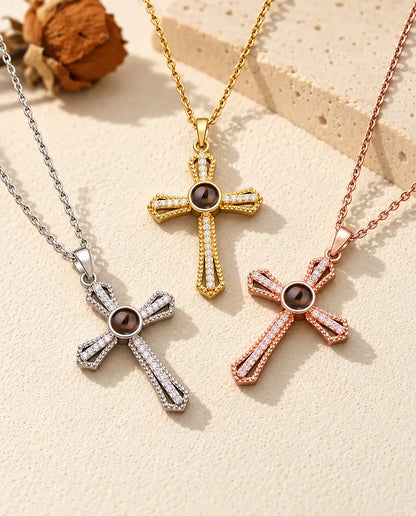 I tre colori della collana con croce a pavé e foto dentro disposti su gesso color crema