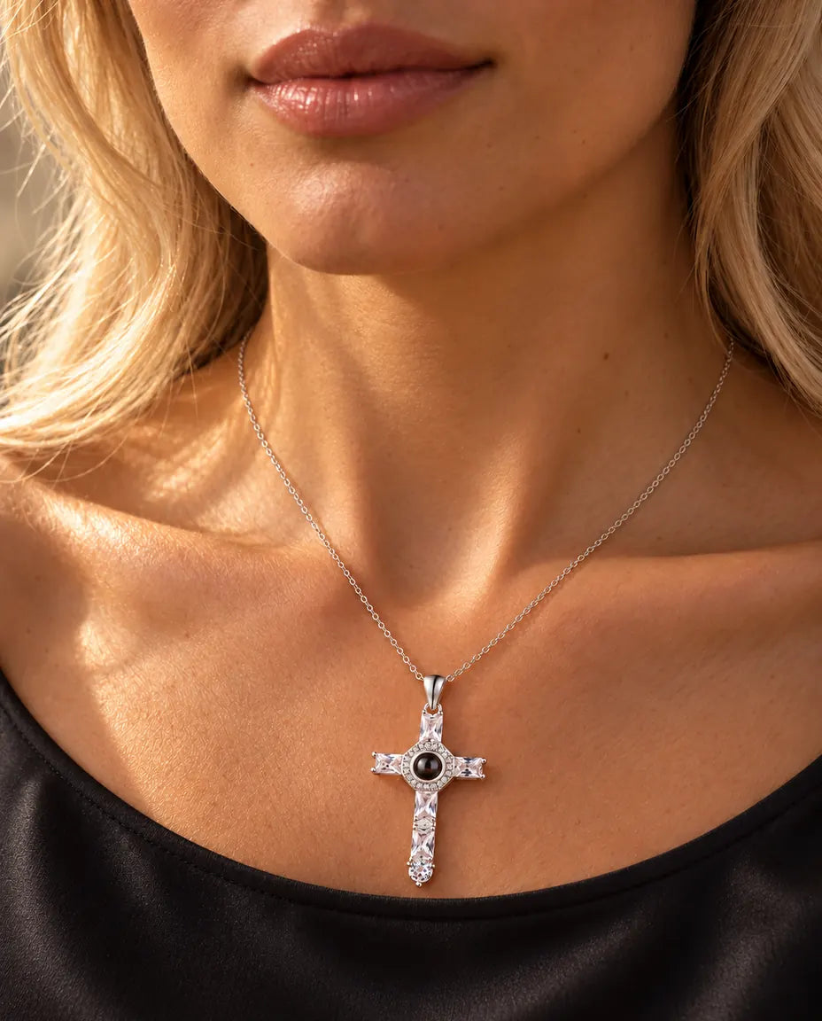 Donna con maglia nera che indossa la collana argentata con la croce di zirconi e foto dentro