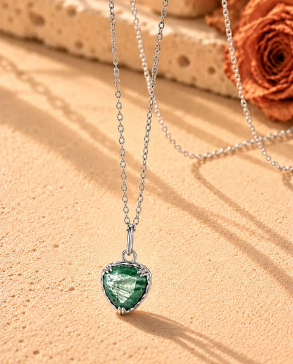 Collana con Ciondolo Cuore in Agata Muschiata e Argento 925 - vista di tre quarti su una superficie chiara ruvida