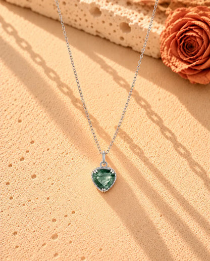 Collana con Ciondolo Cuore in Agata Muschiata e Argento 925 - la collana intera distesa a lunga V su una superficie chiara ruvida