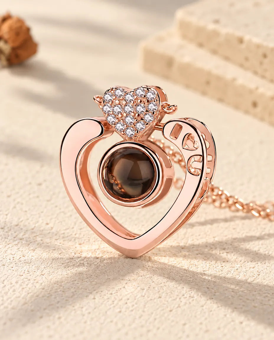 Primo piano del cuore aperto color oro rosa con le lettere I, cuore, U traforate e il cuoricino a pavé