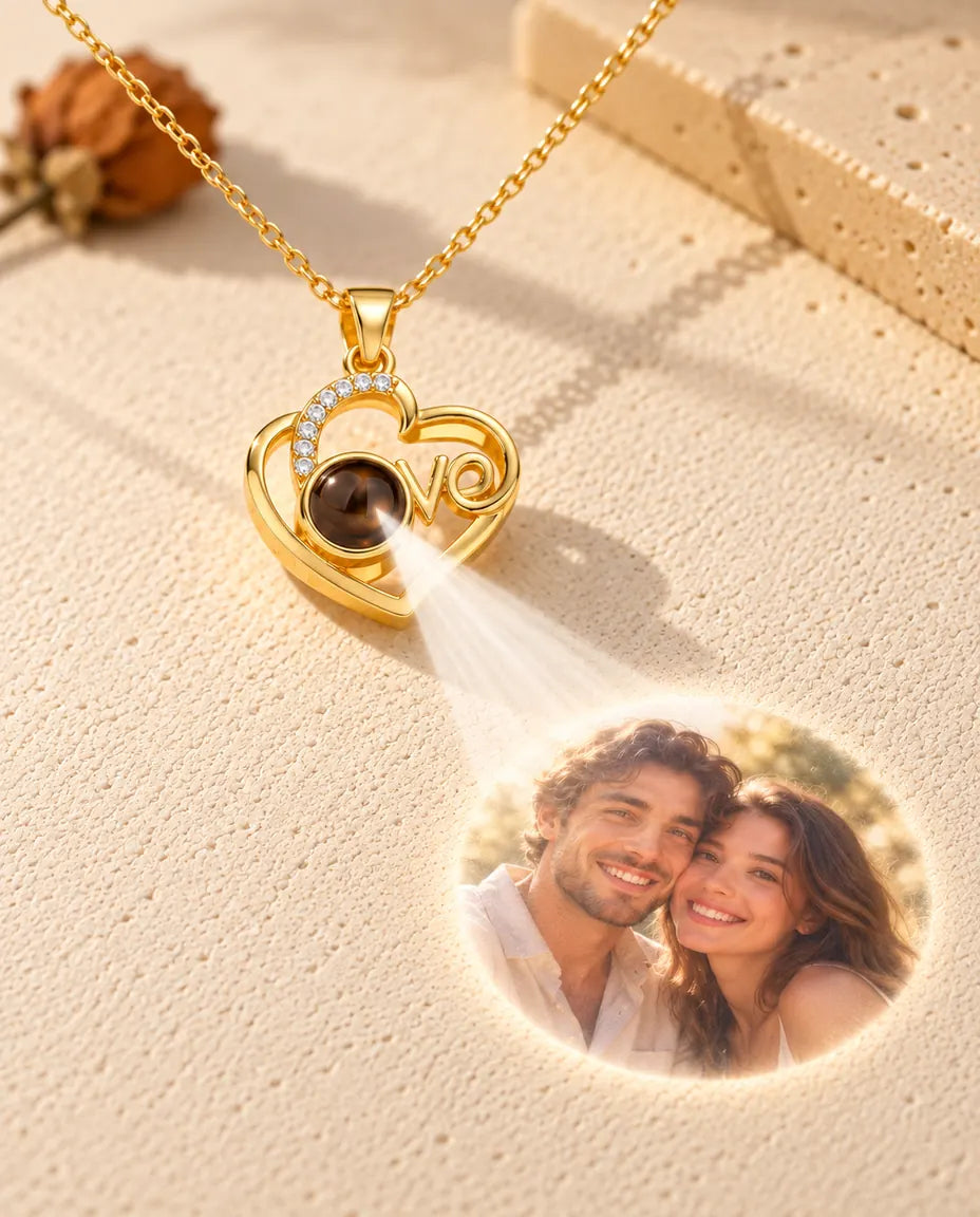 Collana cuore Love dorata che proietta dalla pietra la foto di una coppia sul gesso color crema