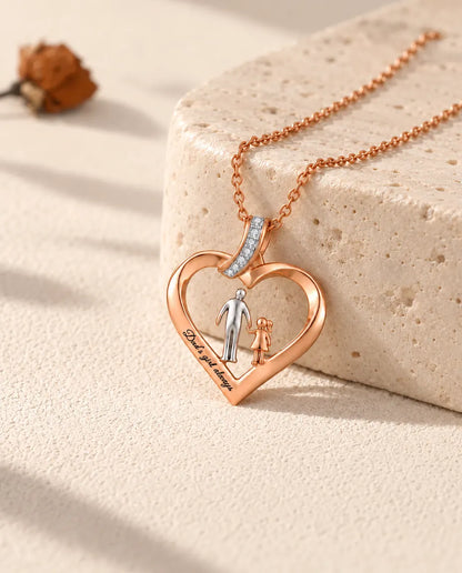 Collana personalizzata con cuore papà e figlia color oro rosa, appoggiata a un blocco di travertino