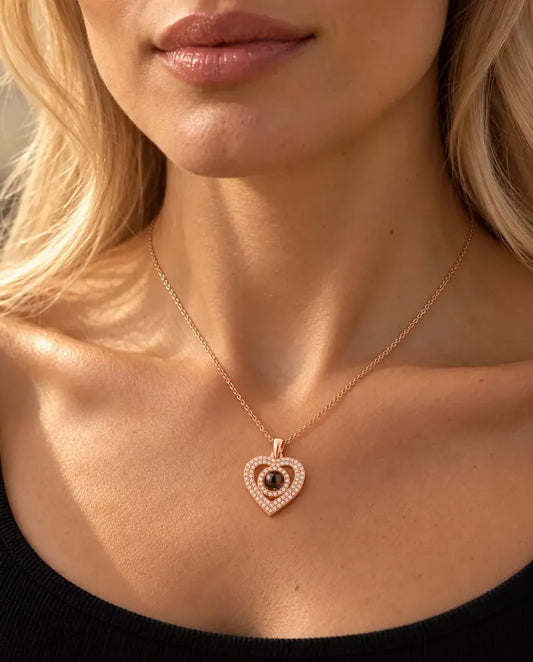 Donna con un top nero in maglia che indossa la collana color oro rosa con doppio cuore a pavé e foto dentro