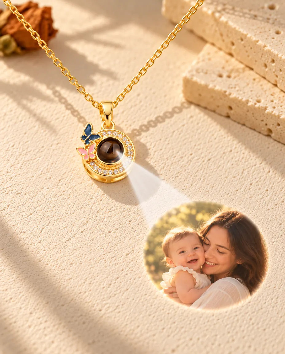 La luce che attraversa la pietra marrone del ciondolo dorato con farfalle proietta la foto di una mamma con il bebè