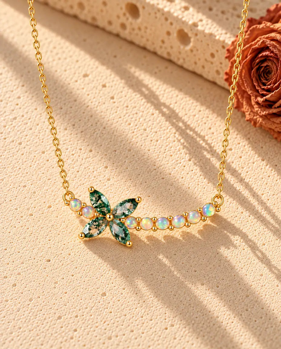 Collana Fiore Agata Muschiata in Argento 925 Placcato Oro - appoggiata su una superficie chiara ruvida accanto a un blocco di travertino
