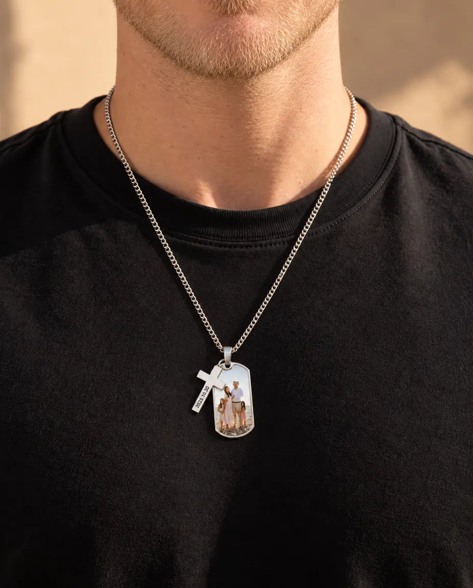 Uomo che indossa la collana con foto e croce incisa su una maglietta nera