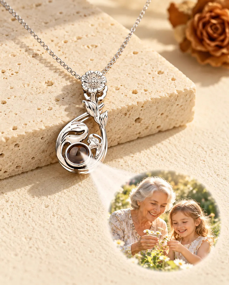 Collana argentata a goccia fiorita che proietta la foto di una nonna con la nipote sull'intonaco